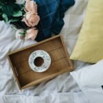 white and brown ceramic teacup on brown wooden tray