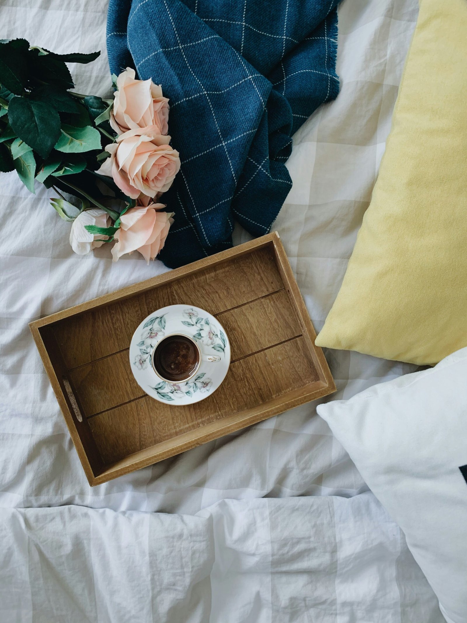 white and brown ceramic teacup on brown wooden tray